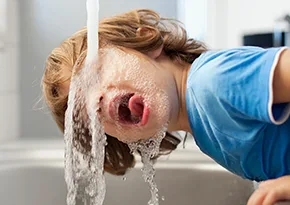 Child drinking from a tap